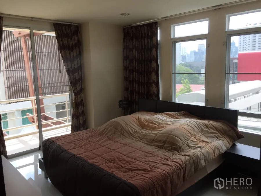 คอนโด ให้เช่าหรือขายในWatthana, Bangkok - ห้องนอนสว่างพร้อมประตูกระจกบานเลื่อนออกสู่ระเบียงและวิวเส้นขอบฟ้าเมือง