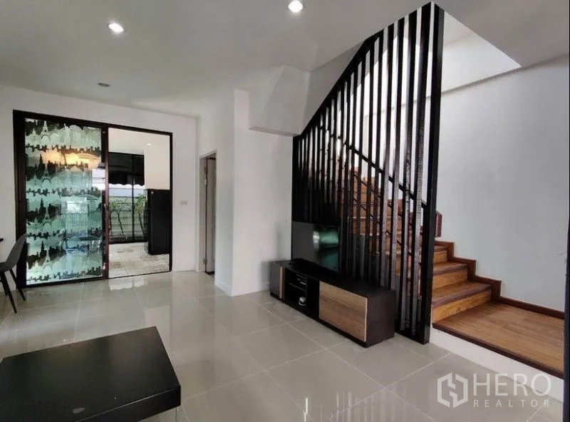 ทาวน์เฮาส์ ให้เช่าในSuan Luang, Bangkok - ห้องนั่งเล่นมองเห็นบันไดไม้และซี่กั้นสีดำ