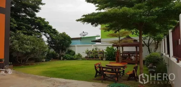 工厂 出售在Bang Phli, Samut Prakan - 厂区庭院的草坪与绿树，带木质凉亭与户外座椅。