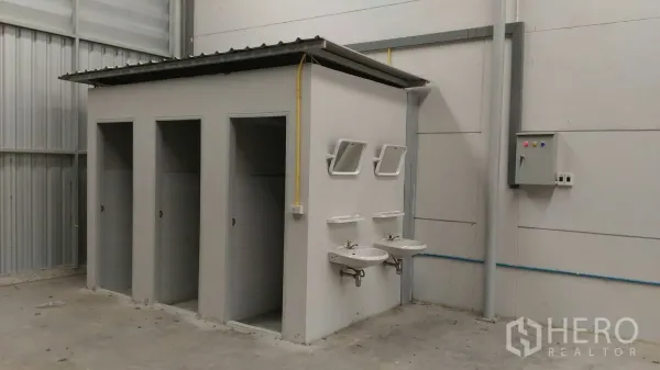货栈 出租在Lam Luk Ka, Pathum Thani - 仓库内卫生区，多个隔间、双洗手盆、镜子与电控箱
