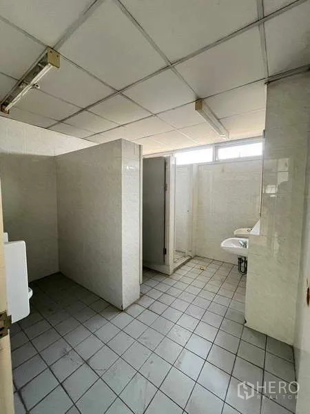 货栈 出租在Lat Krabang, Bangkok - 仓库内公共卫生间，隔间与洗手池、瓷砖墙面。