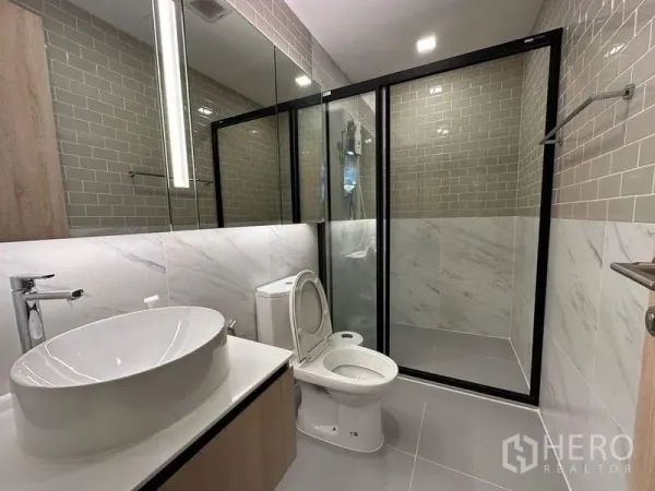 公寓 出租在Ratchathewi, Bangkok - 现代卫浴，台上盆、坐便器与玻璃淋浴间，墙面地铁砖。