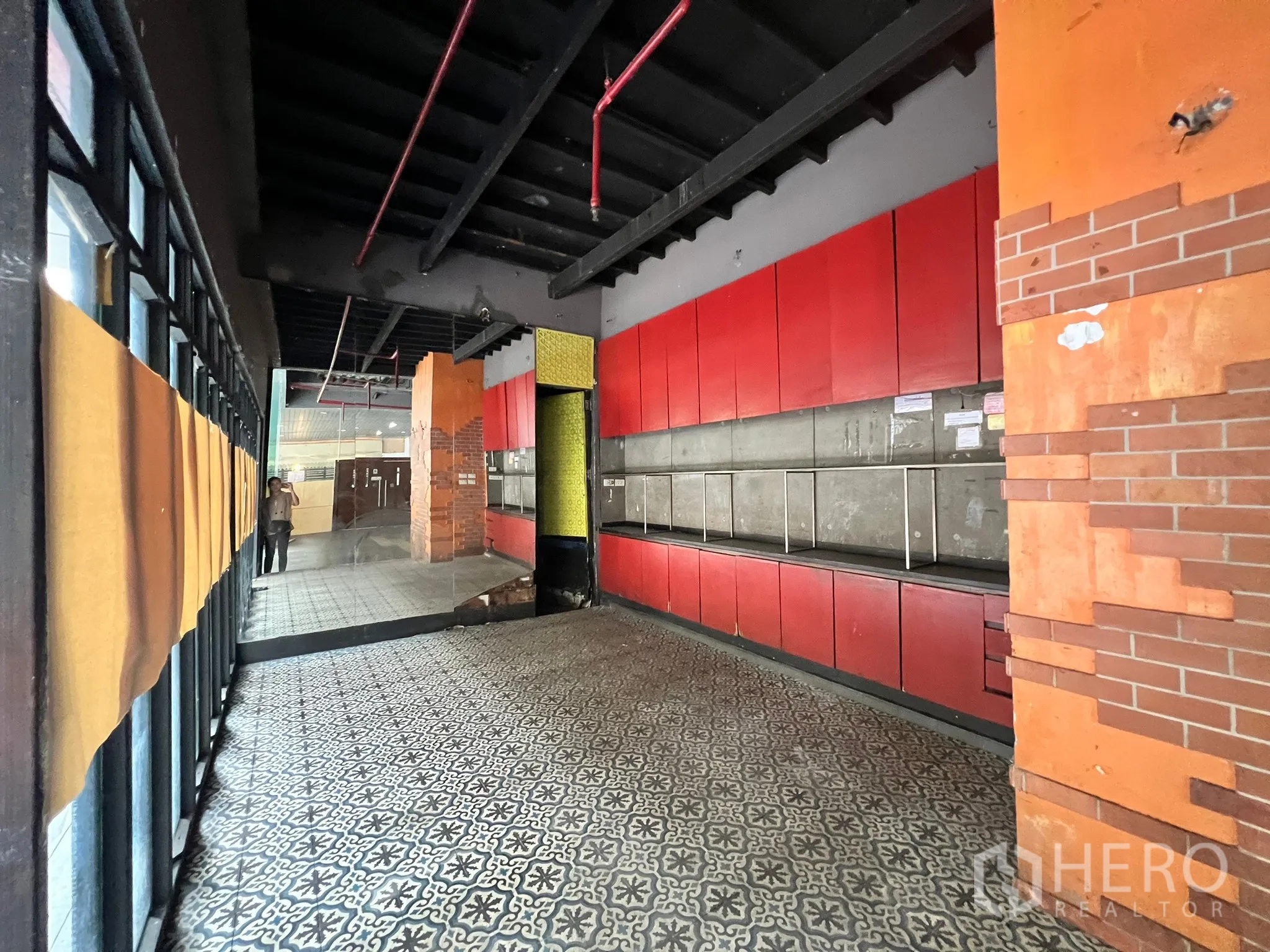 零售空间 出租在Watthana, Bangkok - 前场铺花纹地砖，红色壁柜与大面积窗玻璃。