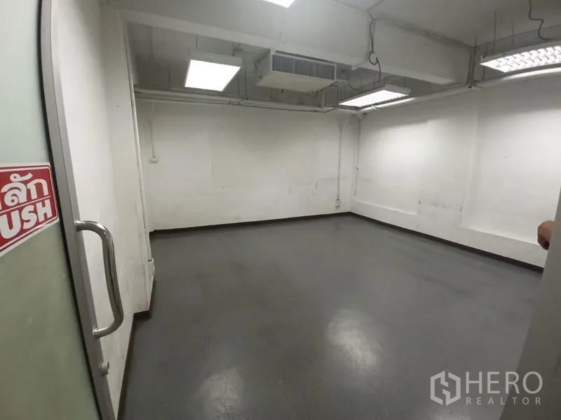 สำนักงาน ให้เช่าในRatchathewi, Bangkok - ห้องสำนักงานเปล่าพื้นสีเทา ผนังสีขาว ฝ้าเพดานแบบลอยและไฟฟลูออเรสเซนต์.