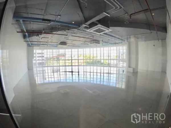 零售空间 出租在Khlong Toei, Bangkok - 宽敞铺面，通高玻璃、反光地面与工业风裸露管线天花。