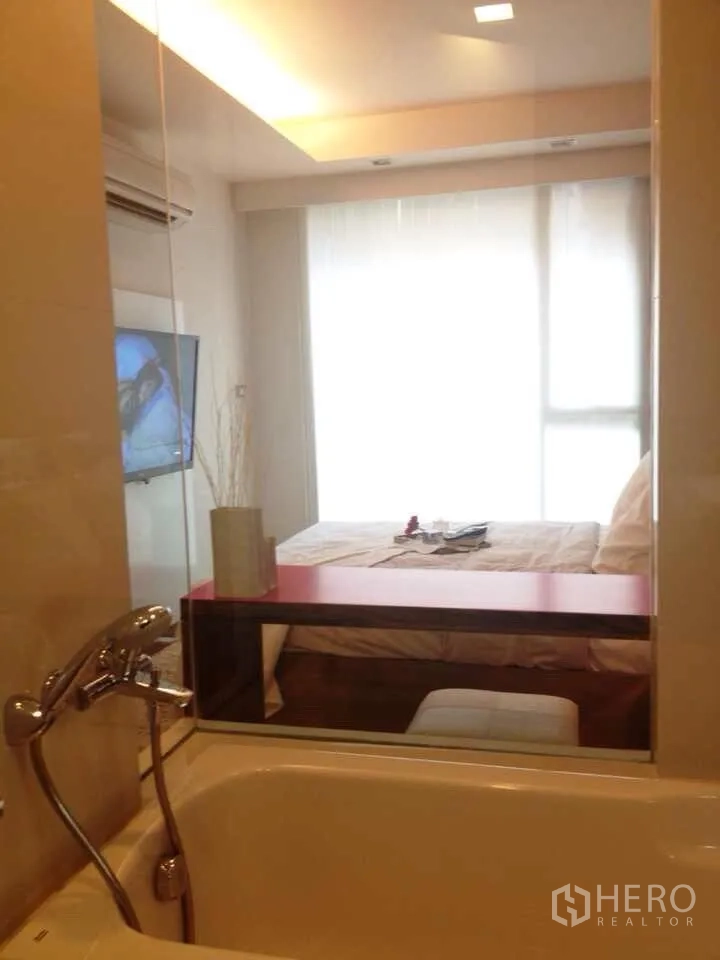 คอนโด ให้เช่าในWatthana, Bangkok - ห้องน้ำมีอ่างอาบน้ำกั้นกระจก มองเห็นห้องนอนสว่างพร้อมหน้าต่างบานใหญ่และทีวี