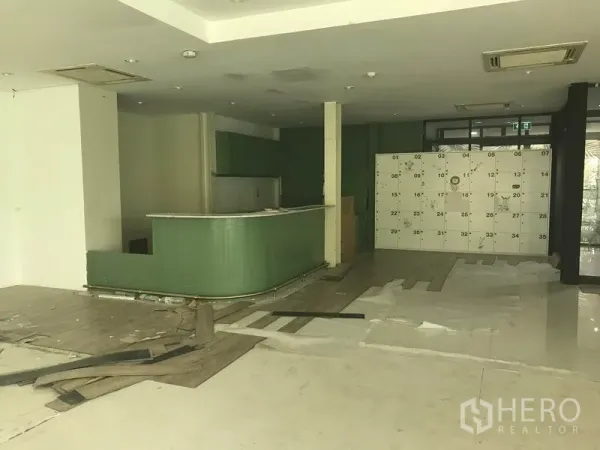 零售空间 出租在Watthana, Bangkok - 前场设弧形服务吧台、内置柜体与编号储物柜墙面。