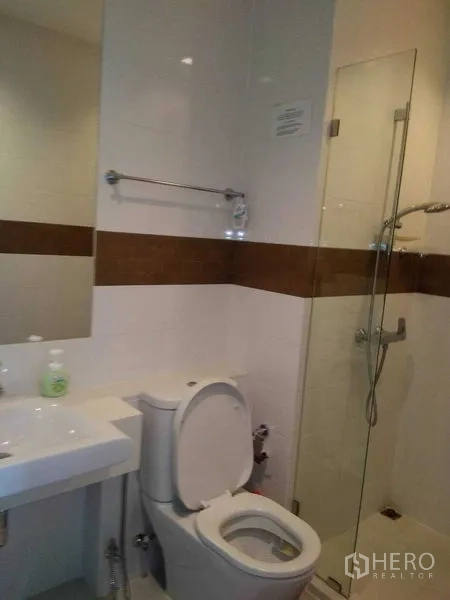 Condominium for rent in Watthana, Bangkok - Second bathroom featuring glass shower enclosure, sink, and toilet.