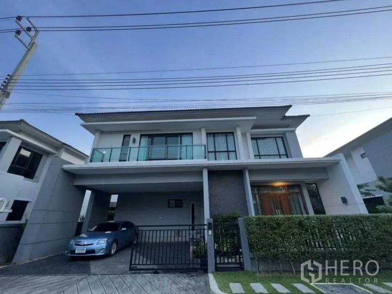 บ้าน ให้เช่าในMueang Nonthaburi, Nonthaburi - ด้านนอกบ้านเดี่ยวสองชั้น มีที่จอดรถในร่มและระเบียง พร้อมรั้วหน้าบ้าน