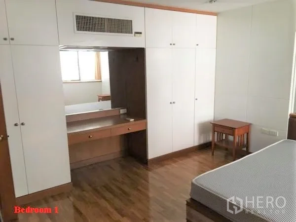 公寓 出租在Khlong Toei, Bangkok - 采光良好的卧室，内置白色衣柜与梳妆台，木地板，配床架。