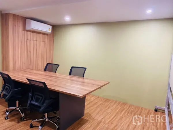 办公空间 出租在Bang Rak, Bangkok - 会议室，长木质会议桌、网面座椅、空调与浅绿色墙面