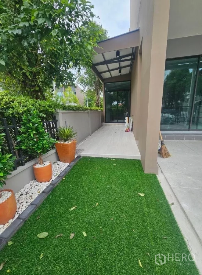 ทาวน์เฮาส์ ให้เช่าในSaphan Sung, Bangkok - สวนหน้าบ้านปูหญ้าเทียม กระถางต้นไม้ และทางเดินเข้าบ้าน