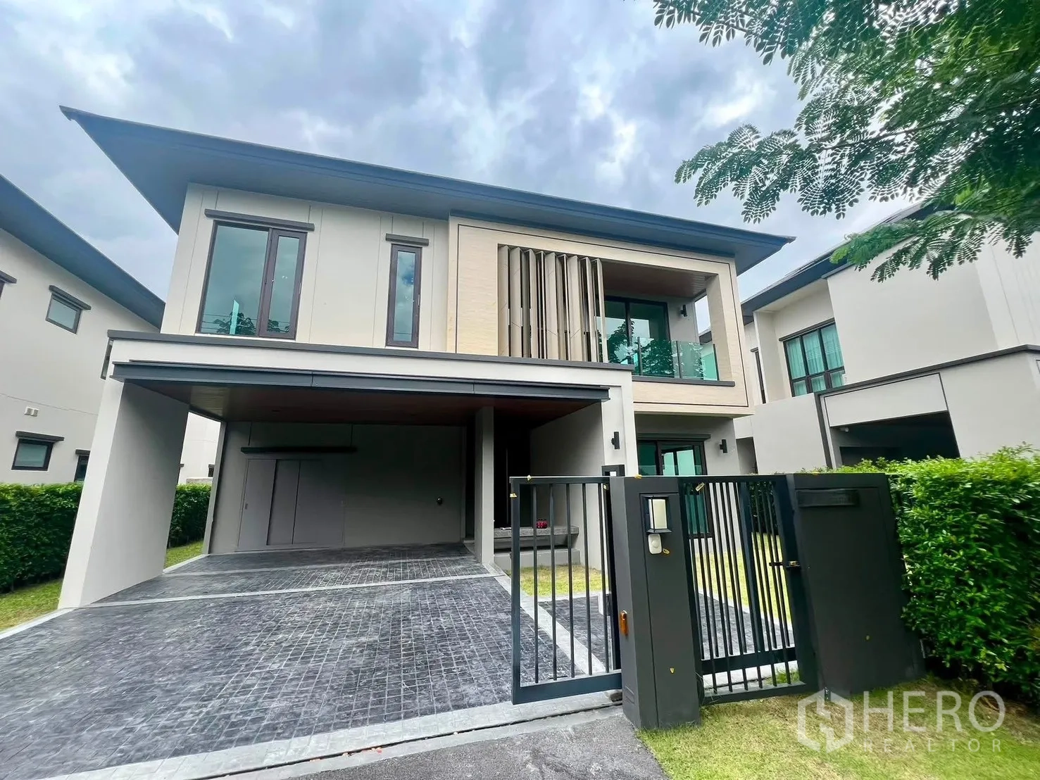 Detached House for rent in Bang Phli, Samut Prakan - Modern two-storey detached house with gated entry, balcony, and driveway.