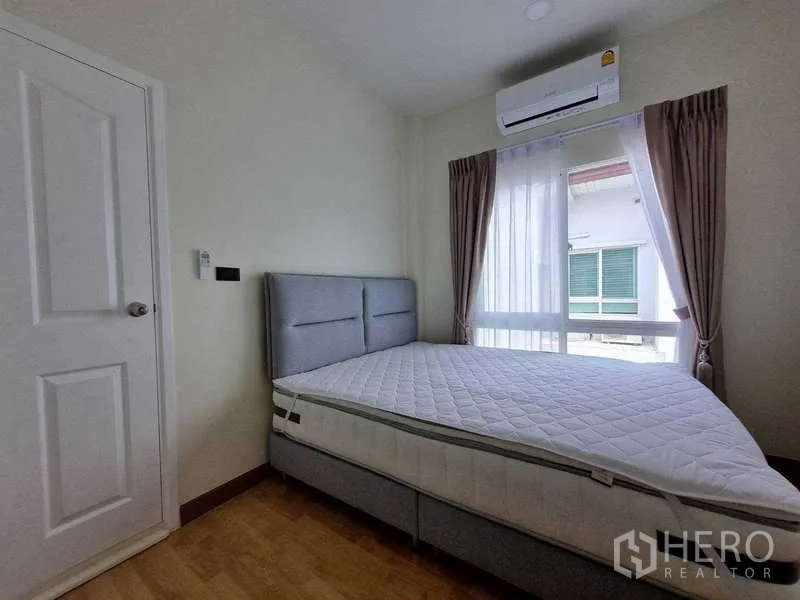 ทาวน์เฮาส์ ให้เช่าในWang Thonglang, Bangkok - ห้องนอนมีหน้าต่างบานใหญ่ ผ้าม่าน แอร์ และเตียงสีเทา