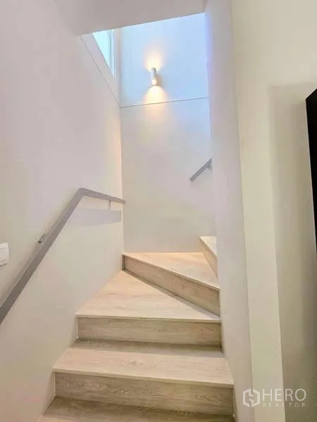 Detached House for rent or sale in Prawet, Bangkok - Master bedroom angle with white metal bedframe and corner windows.