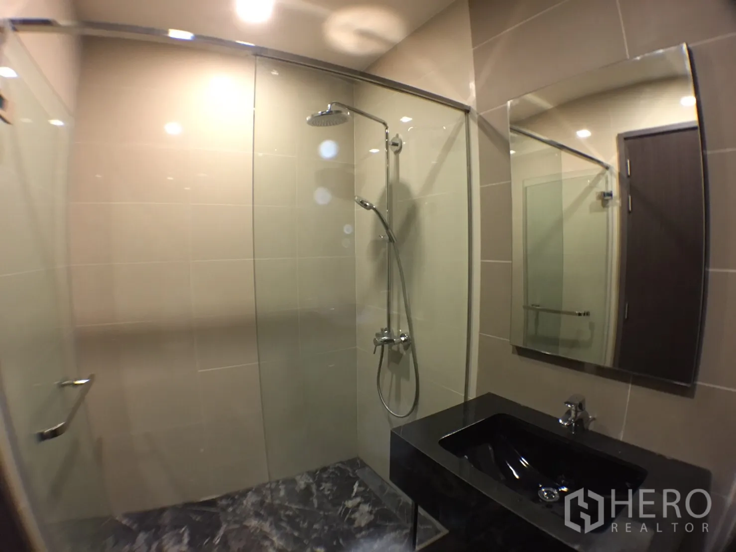 คอนโด ให้เช่าในWatthana, Bangkok - ห้องน้ำสมัยใหม่ มีกระจกกั้นอาบน้ำ ฝักบัวเรนชาวเวอร์ กระจกบานใหญ่ และเคาน์เตอร์หินสีดำ