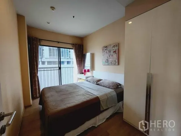 คอนโด ให้เช่าในBangkok - ห้องนอนอบอุ่น เตียงคู่ ประตูกระจกบานเลื่อนออกระเบียง และตู้เสื้อผ้า