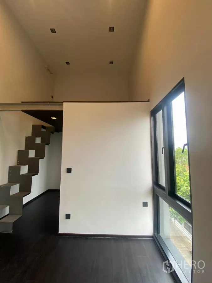 ทาวน์เฮาส์ ให้เช่าในHuai Khwang, Bangkok - ห้องเพดานสูงมีชั้นลอฟต์และบันไดโลหะทรงประติมากรรม.