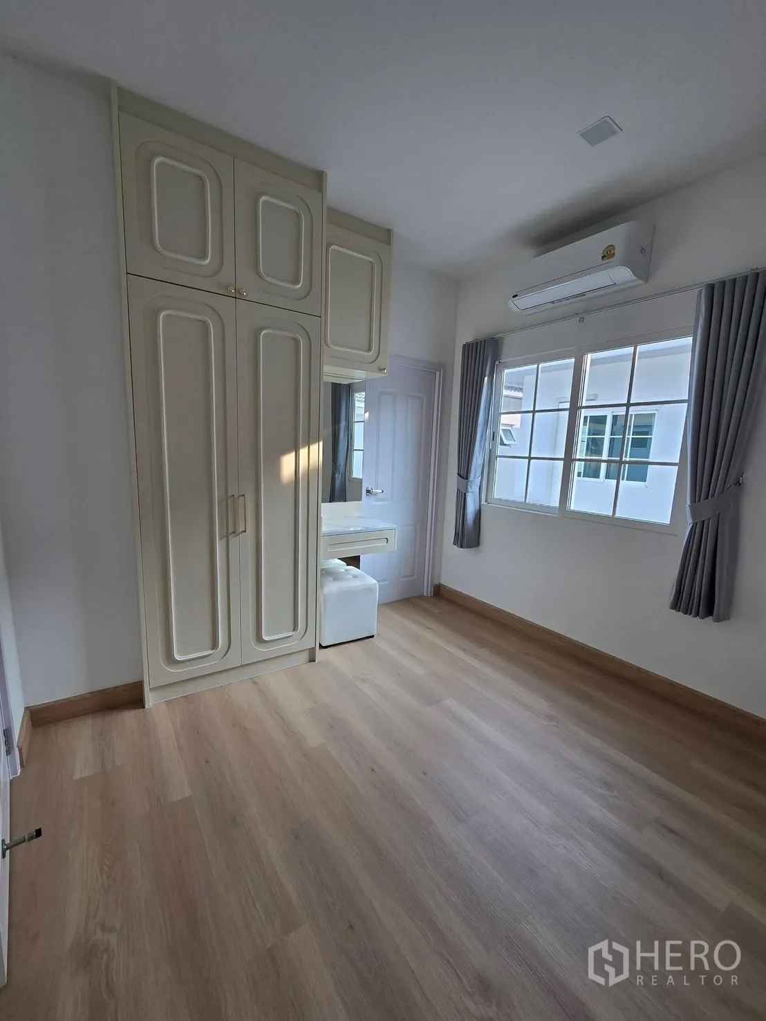 บ้านแฝด for rent in Mueang Samut Prakan, Samut Prakan - ห้องนอนรองพร้อมตู้เสื้อผ้าบิวท์อิน โต๊ะเครื่องแป้ง เครื่องปรับอากาศ และพื้นลามิเนตลายไม้