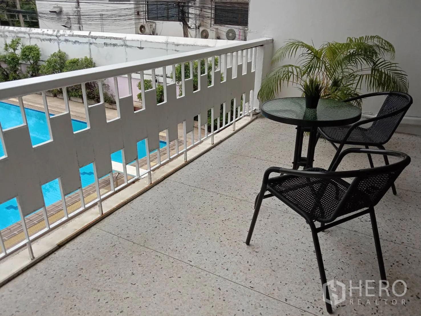 อพาร์ทเมนท์ ให้เช่าในRatchathewi, Bangkok - ระเบียงกว้างพร้อมชุดโต๊ะเก้าอี้ มองเห็นสระว่ายน้ำสีฟ้าในโครงการ ย่านอโศก