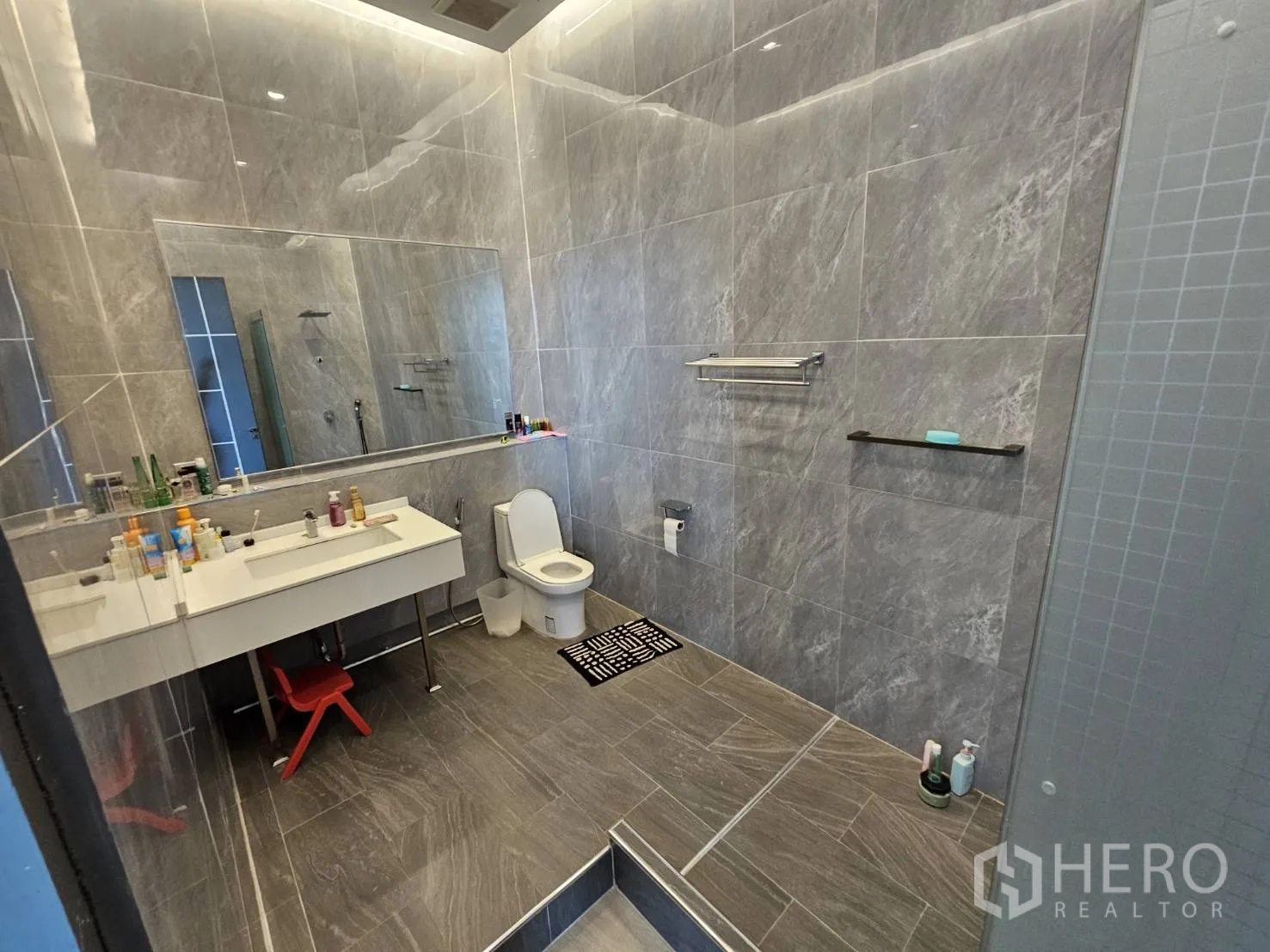 สำนักงาน ให้เช่า - ห้องน้ำสไตล์ร่วมสมัย ผนังกรุกระเบื้องลายหินอ่อน กระจกบานใหญ่ อ่างล้างหน้าและโซนฝักบัว.