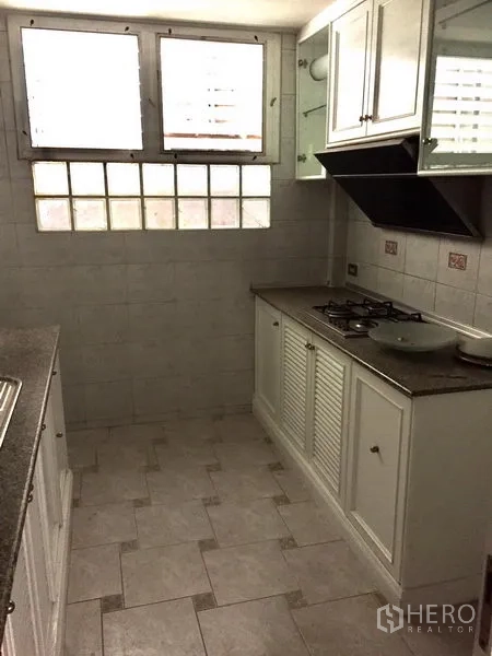 ทาวน์เฮาส์ ให้เช่าในWatthana, Bangkok - ครัวบิลท์อินตู้สีขาว เตาแก๊ส เครื่องดูดควัน และหน้าต่างบานเล็ก