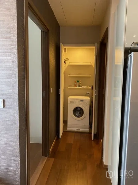 公寓 出租在Watthana, Bangkok - 走廊内独立洗衣柜，前置洗衣机与收纳层架。