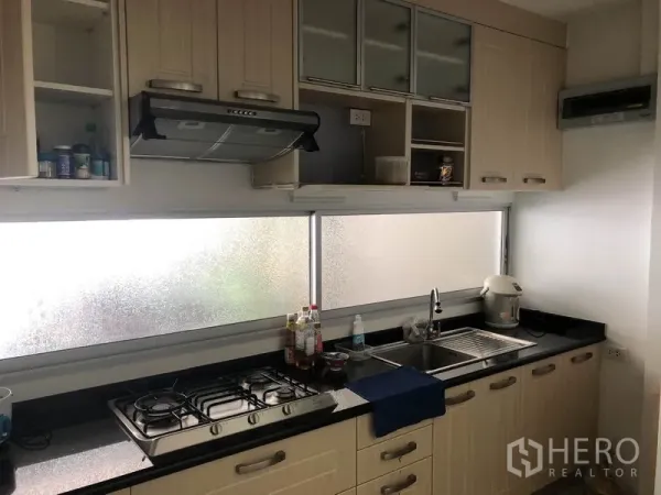 ทาวน์เฮาส์ ให้เช่าหรือขายในSuan Luang, Bangkok - ครัวบิวท์อินโทนไม้ ติดเตาแก๊ส เครื่องดูดควัน เคาน์เตอร์หินสีดำยาว ใต้หน้าต่างกระจกฝ้า