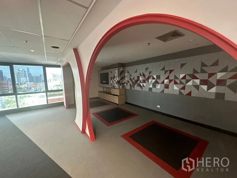 Office Space for rent in Khlong Toei, Bangkok - Breakout zone with red arched frames, geometric feature wall, and large windows facing the skyline.