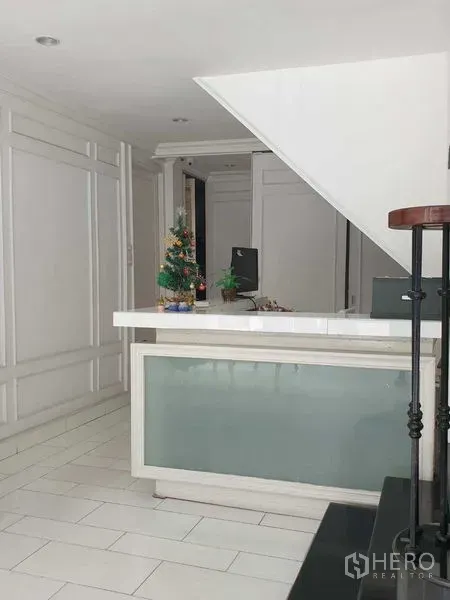 零售空间 出租在Huai Khwang, Bangkok - 曼谷辉煌区零售空间的前台，位于楼梯下方，白色墙面装饰明亮。