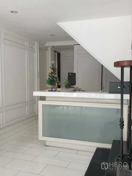 零售空间 出租在Huai Khwang, Bangkok - 曼谷辉煌区零售空间的前台，位于楼梯下方，白色墙面装饰明亮。