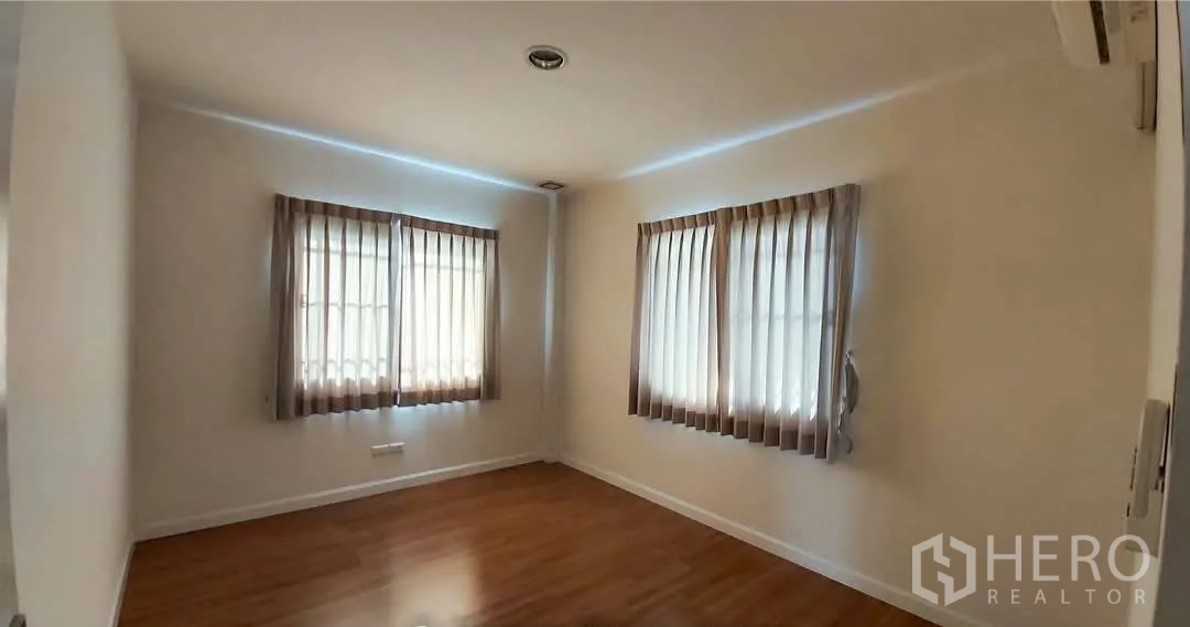 บ้าน for sale in Bang Kapi, Bangkok - ห้องนอนรองสว่าง มีหน้าต่างมุมสองด้านและผ้าม่าน พื้นไม้