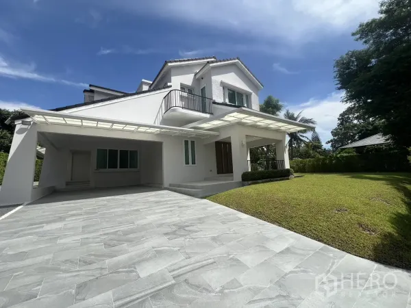 独立式住宅 出租在Mueang Samut Prakan, Samut Prakan - 宽敞的铺砖车道，带有遮雨车棚与前庭草坪。