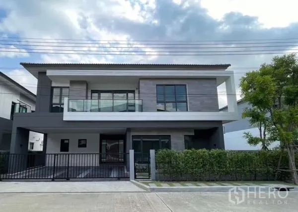 Detached House for rent in Bang Phli, Samut Prakan - Front facade of a modern two-storey detached house with glass balcony and driveway gate.