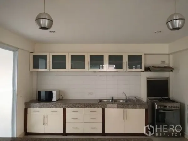 บ้าน ให้เช่าในWatthana, Bangkok - ห้องครัวบิวท์อินโทนขาว เคาน์เตอร์หินแกรนิต อ่างล้างจานคู่ และเตาแก๊ส