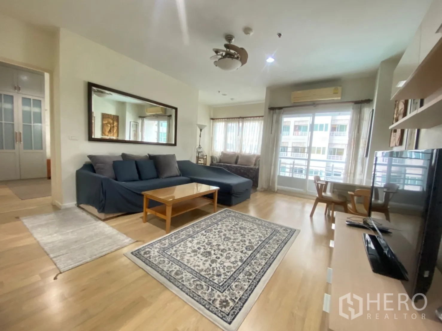 คอนโด ให้เช่าในBang Kapi, Bangkok - ห้องนั่งเล่นกว้าง โซฟา L รูป พรม กระจกบานใหญ่เปิดออกสู่ระเบียง