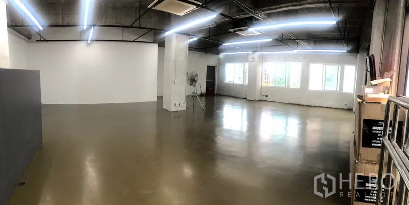 สำนักงาน ให้เช่าในKhlong Toei, Bangkok - ออฟฟิศเปิดโล่งพร้อมหน้าต่างยาวตลอดแนว เพดานคอนกรีต ไฟเส้น และกล่องวางใกล้ทางเข้า