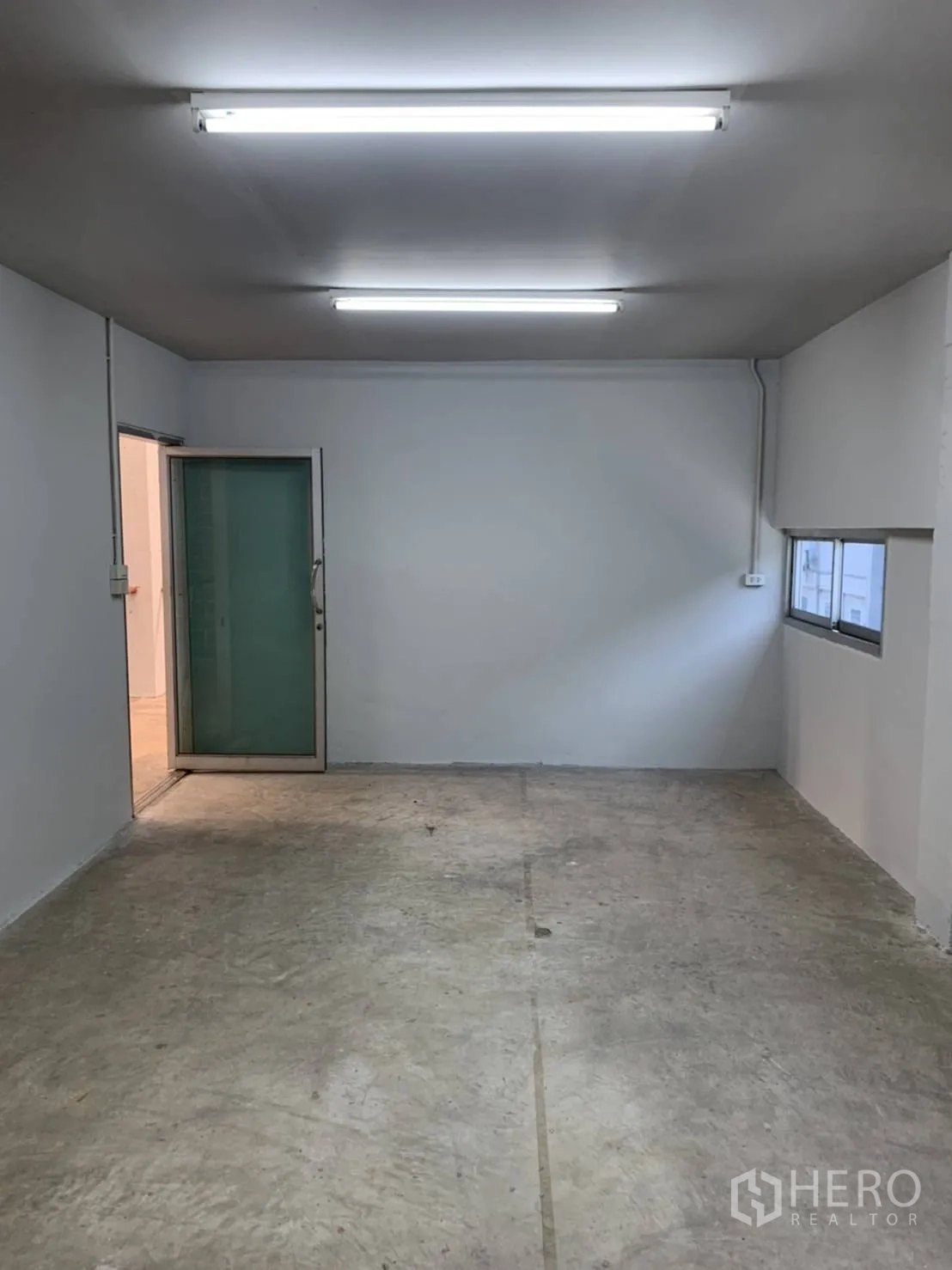 Warehouse for rent in Khlong Sam Wa, Bangkok - Upstairs office room with bright strip lighting and doorway.