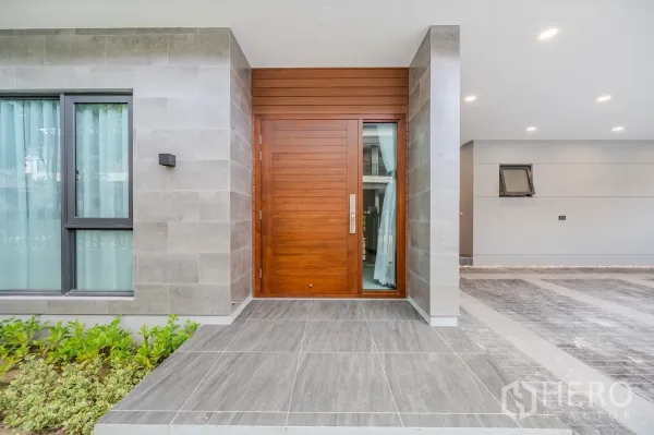 Detached House for rent in Bang Phli, Samut Prakan - Wide wooden front door on tiled porch with grey stone cladding
