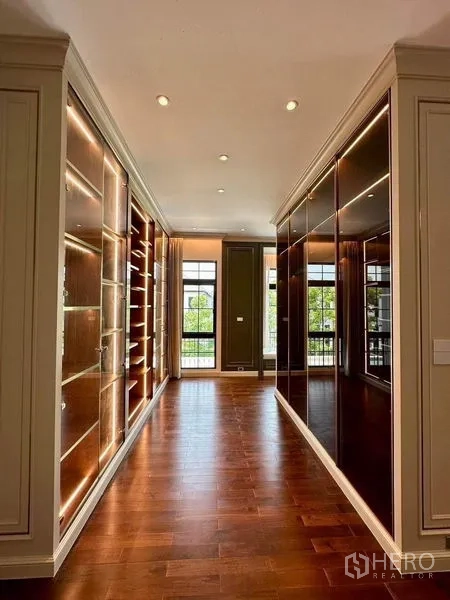 Detached House for sale - Walk-in wardrobe corridor with illuminated display shelves and mirrored cabinetry.