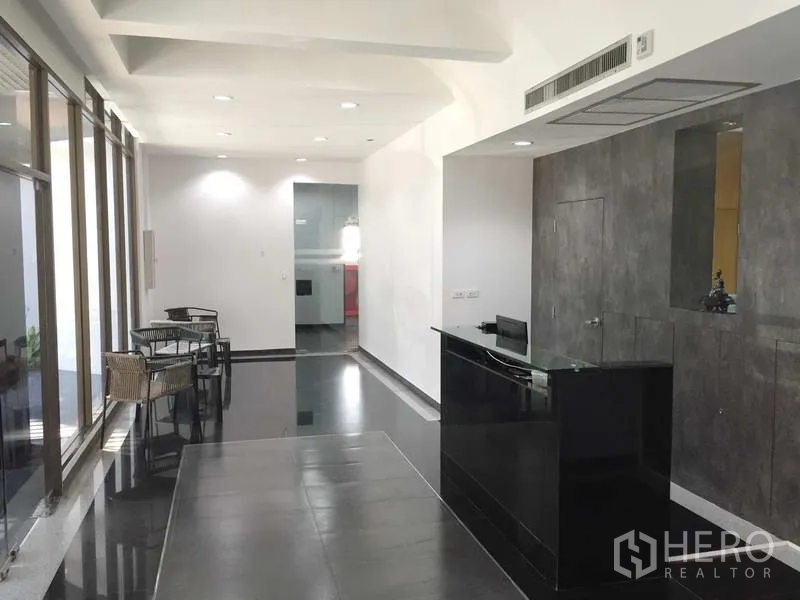 Office Space for rent in Khlong Toei, Bangkok - Building lobby with a sleek reception desk, seating area, and full-height windows.