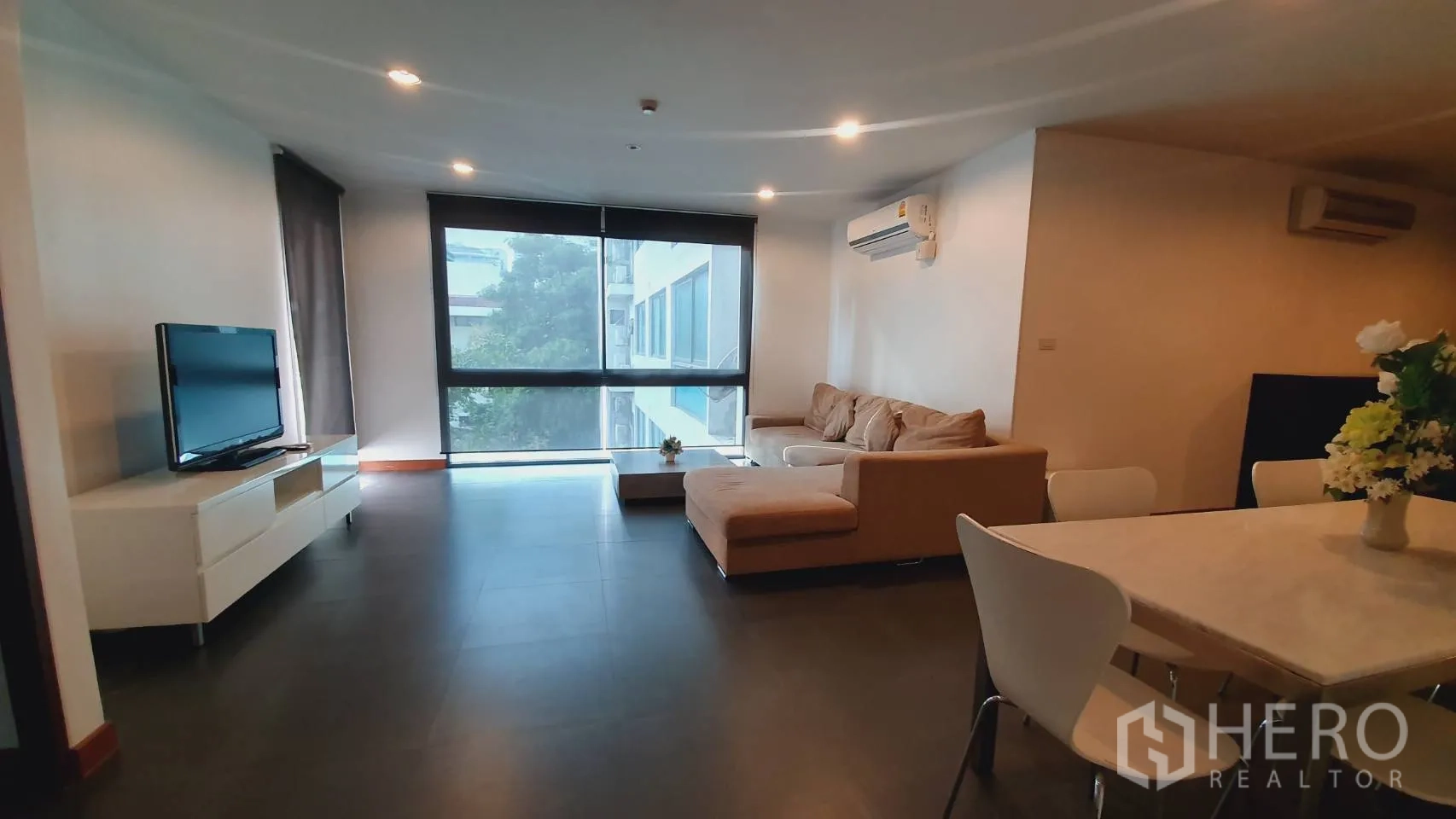 คอนโด ให้เช่าในKhlong Toei, Bangkok - ห้องนั่งเล่นสว่างด้วยหน้าต่างกว้าง ม่านกันแสง และชั้นวางทีวี