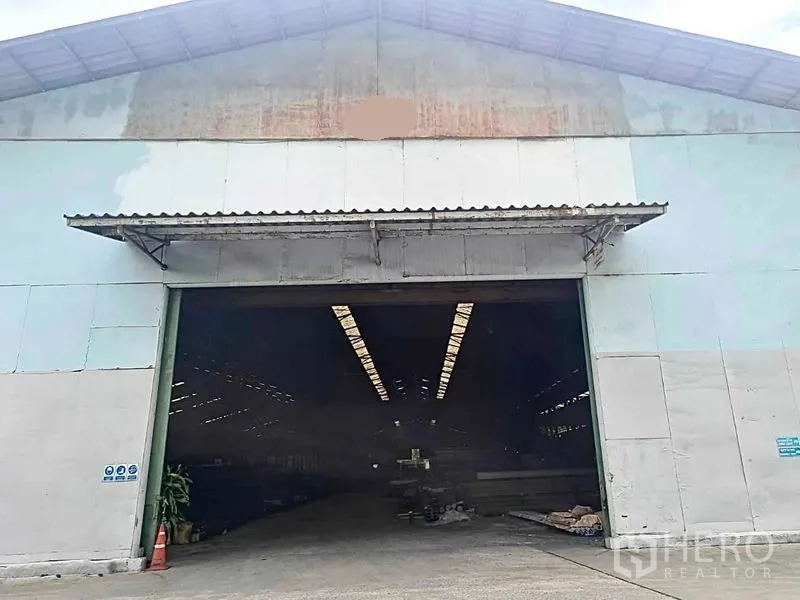 Warehouse for rent in Phra Pradaeng, Samut Prakan - Wide entrance of a metal-clad warehouse with canopy and sliding doors