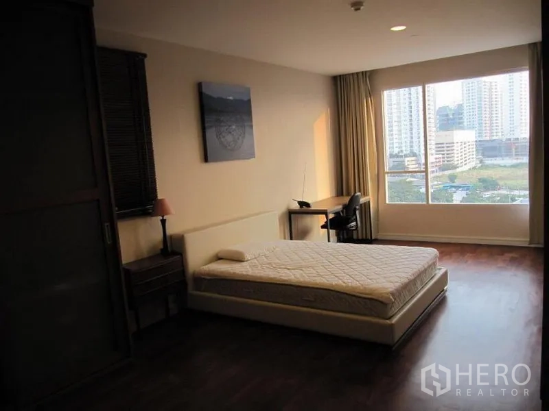คอนโด ให้เช่าในKhlong Toei, Bangkok - ห้องนอนใหญ่ เตียงเตี้ย โต๊ะทำงานริมหน้าต่างบานกว้าง มองเห็นวิวเมือง