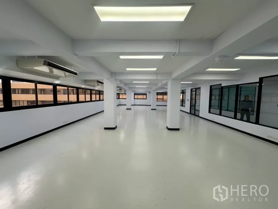 办公空间 出租 - 明亮办公区，一侧为连续窗，另一侧为玻璃隔间，吊顶空调机组。