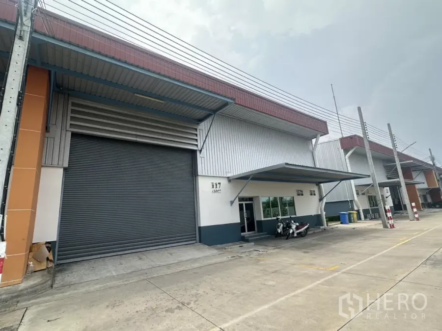 โรงงาน ให้เช่าในBang Phli, Samut Prakan - ด้านหน้าโรงงานและโกดังในบางพลี ประตูม้วนขนาดใหญ่ มีหลังคากันฝนและลานขนส่ง