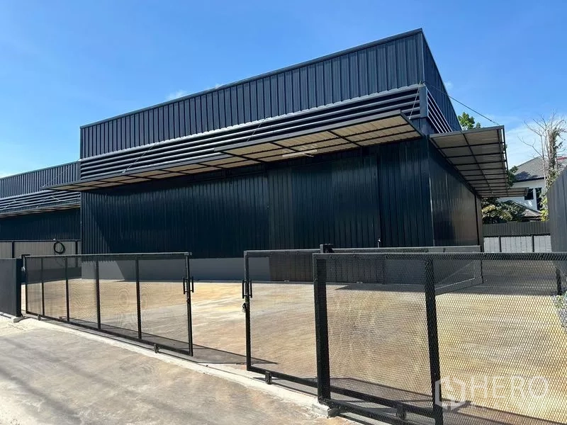 Warehouse for rent in Wang Thonglang, Bangkok - Gated black metal warehouse with a wide concrete yard and covered loading awning in Wang Thonglang, Bangkok.