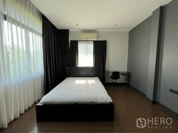 บ้าน ให้เช่าหรือขายในBang Kapi, Bangkok - ห้องนอนหลักกว้าง มีหน้าต่างมุมบานใหญ่ ผ้าม่านทึบ และพื้นไม้