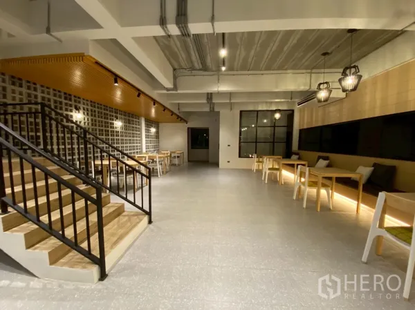 Detached House for sale in Mueang Nakhon Pathom, Nakhon Pathom - Spacious open-plan hall featuring a wooden staircase, pendant lights and café-style seating.