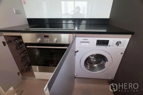 คอนโด ขายในKhlong San, Bangkok - ครัวบิวท์อินท็อปหินดำ พร้อมเตาอบ เตาไฟฟ้า และเครื่องซักผ้าฝาหน้า